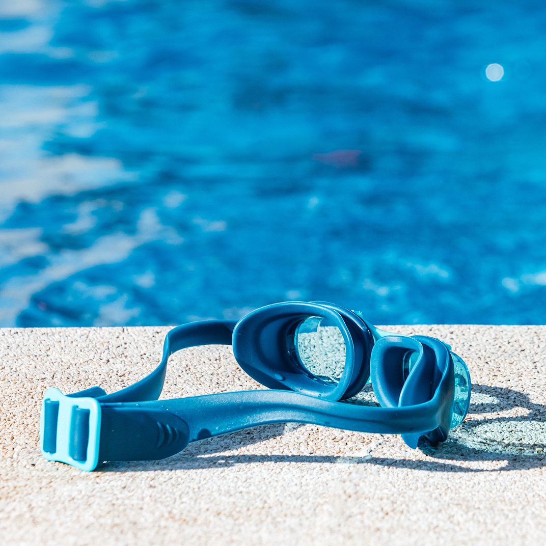 Swimming goggles resting at the pool edge