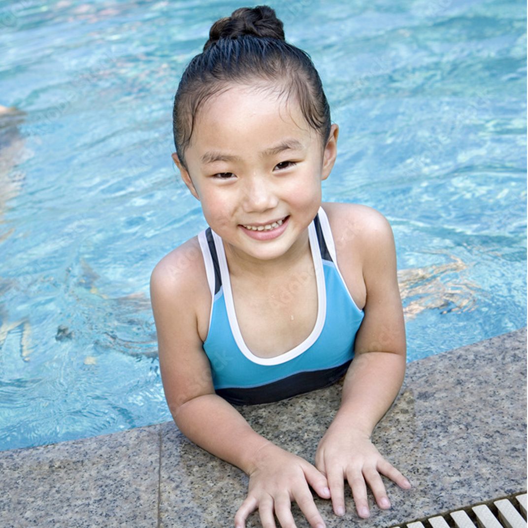 A smiling child at the edge of the pool